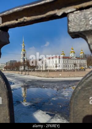 Russie, Saint-Pétersbourg, le 02 avril 2021 : clocher de la cathédrale navale de Saint-Nicolas à travers le réseau forgé en une journée ensoleillée de printemps, une dérive de glace Banque D'Images