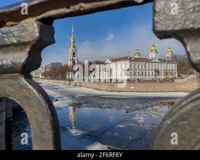 Russie, Saint-Pétersbourg, le 02 avril 2021 : clocher de la cathédrale navale de Saint-Nicolas à travers le réseau forgé en une journée ensoleillée de printemps, une dérive de glace Banque D'Images