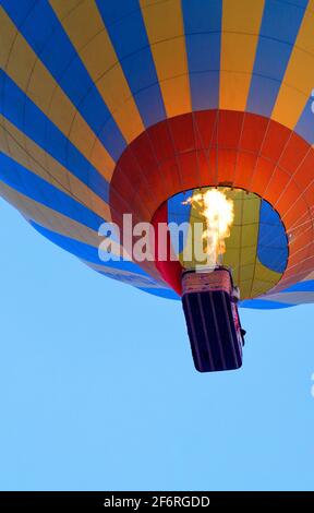 Fragment d'un ballon avec un panier et une flamme de feu provenant d'un brûleur qui chauffe l'air. Banque D'Images