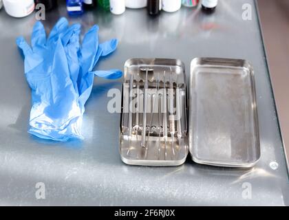 Instruments dentaires et gants médicaux sur la table Banque D'Images