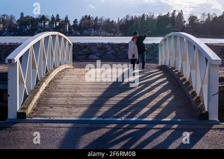 Helsinki / Finlande - 2 AVRIL 2021 : un couple âgé se promenait sur le front de mer. L'homme qui pointe sur la distance. Banque D'Images