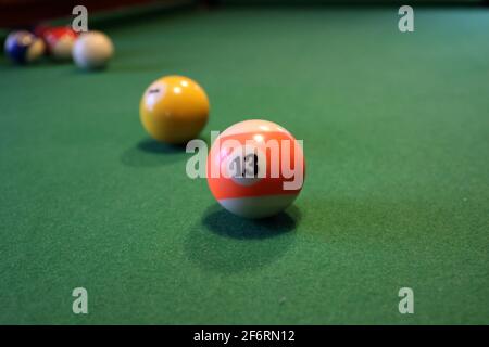 Boules de billard colorées sur une table de billard verte. Boule de billard avec le numéro treize. Banque D'Images