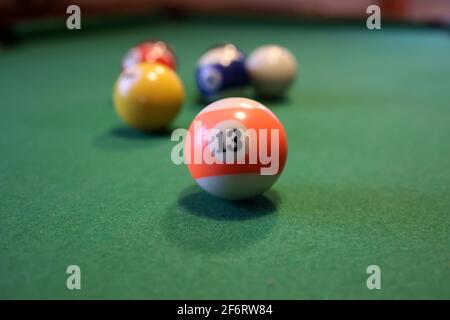 Boules de billard colorées sur une table de billard verte. Boule de billard avec le numéro treize. Banque D'Images