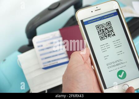 Le certificat vert numérique de l'Union européenne avec le code QR sur l'écran d'un smartphone tenu par une main à l'aéroport pour voyager. Vaccination Banque D'Images