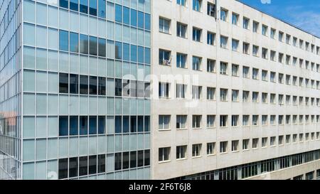 Bâtiment de bureau moderne remplissant le cadre avec de longues rangées de fenêtres carrées motif et façade blanche avec bloc de verre, Bucarest, Roumanie Banque D'Images