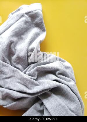 Tissu tricoté gris sur fond jaune Banque D'Images