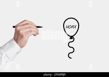 Homme d'affaires avec un stylo est sur le point de faire apparaître une icône de bulle avec le mot Hoax. Révéler le concept des faits. Banque D'Images