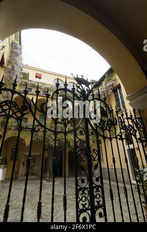 Les portes en fer forgé très ornées et l'élégante cour du Palazzo dalla Rosa Prati, un hôtel près du Duomo à Parme, en Italie. Banque D'Images