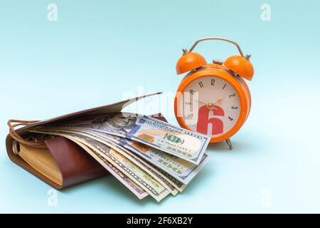 Radio-réveil orange, dollars, ordinateur portable sur fond bleu, espace de copie. Concept de réussite commerciale. Concept d'économie d'argent. Banque D'Images