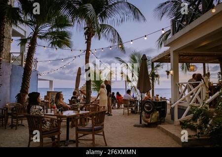 Curaçao, Antilles néerlandaises Mars 2021, les personnes dînant sur la plage Curaçao île des Caraïbes, restauré coloré bâtiments coloniaux à Pietermaai Banque D'Images