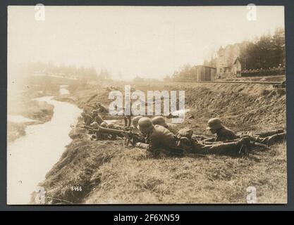 La photo montre un groupe de soldats avec des mitrailleuses qui se trouvent sur le sol entre un rail de chemin de fer et un petit. Les soldats sont équipés de la machine mg 08/15.UN homme se tient debout au milieu et de nombreux soldats le regardent.le décor semble être à droite détendu pour une bataille continue que le texte original indique.texte original: « le département allemand à puces est en bataille avec les gardes rouges du chemin de fer Hanko healthfors. » la photo montre un groupe de soldats avec des mitrailleuses qui se trouvent sur le sol entre un rail de chemin de fer et un petit. Les soldats sont équipés de la machine mg 08/15.UN homme se tient debout Banque D'Images