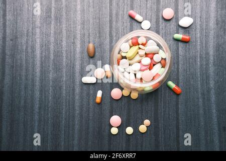 vue de dessus de beaucoup de pilules et capsules colorées qui débordent tableau Banque D'Images