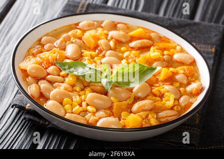 Porotos végétarien ragoût de haricots granados avec maïs, citrouille et oignons gros plan dans un bol sur la table. Horizontal Banque D'Images