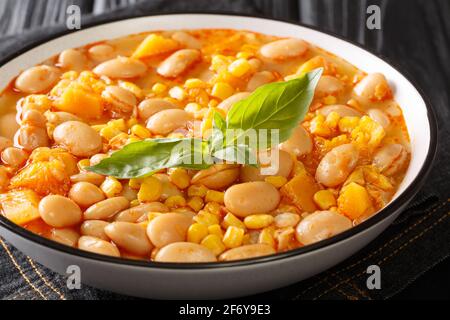 Délicieux haricots à mijoter avec du maïs, de la citrouille et des oignons dans un bol sur la table. Horizontal Banque D'Images