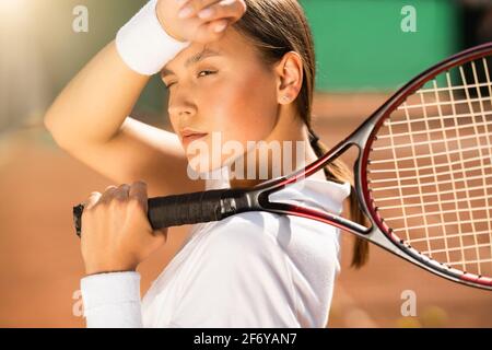 Femme joueur de tennis avec raquette essuye la transpiration de son front Banque D'Images