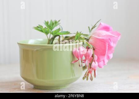 Rose sauvage avec coeur saignant fleurs dans le thé vintage durée de vie de la tasse Banque D'Images