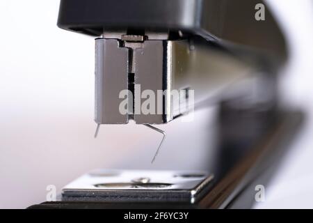 Vue rapprochée de l'avant d'une agrafeuse noire avec une agrafe être poussé vers l'extérieur Banque D'Images