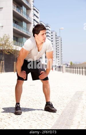 L'homme de l'athlète fatigué après une longue marche dans la ville d'événements sportifs. Banque D'Images