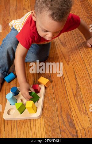 Garçon de deux ans jouant avec un trieur à forme géométrique Banque D'Images