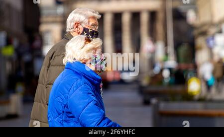 Dundee, Tayside, Écosse, Royaume-Uni. 3 avril 2021. Météo au Royaume-Uni : soleil printanier avec une brise fraîche à travers le nord-est de l'Écosse avec des températures atteignant 12°C. Les gens continuent de passer du temps en plein air à socialiser dans la ville de Dundee avec de nombreux magasins de haute rue encore fermés dans la région de Tayside pendant le niveau 4 Covid-19 Lockdown. Un couple âgé est bien conscient des directives de distanciation sociale et du port de masques de visage passer du temps ensemble dehors en profitant du temps ensoleillé dans le centre-ville. Crédit : Dundee Photographics/Alamy Live News Banque D'Images