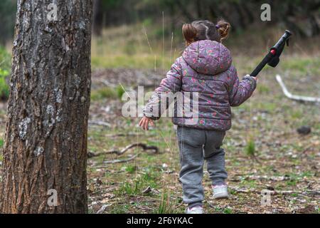 Petite fille randonnée dans les bois sur un froid jour d'automne avec manteau. Des vacances familiales actives avec des enfants. Activités de plein air et santé Banque D'Images