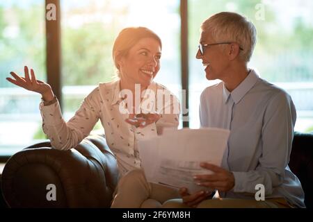 Jeune femme joyeuse encadrée par une femme partenaire senior dans le bureau Banque D'Images