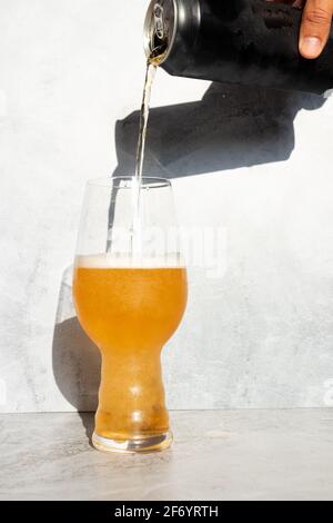 Sert de la bière, d'une canette à un verre de cristal pour IPA Banque D'Images