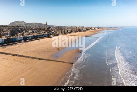 Portobello, Écosse, Royaume-Uni. 3 avril 2021. Le week-end de Pâques, la foule descend sur la plage et la promenade de Portobello pour profiter au maximum des restrictions de voyage récemment relaxantes de Covid-19 et du soleil chaud avec un ciel bleu ininterrompu. Pic; vue aérienne de drone de Portobello plage qui semble assez calme à l'est. Iain Masterton/Alamy Live News Banque D'Images