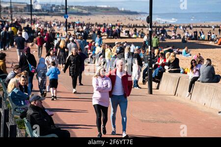 Portobello, Écosse, Royaume-Uni. 3 avril 2021. Le week-end de Pâques, la foule descend sur la plage et la promenade de Portobello pour profiter au maximum des restrictions de voyage récemment relaxantes de Covid-19 et du soleil chaud avec un ciel bleu ininterrompu. Pic; Promenade animée avec les membres du public appréciant le temps. Iain Masterton/Alay Live News Banque D'Images