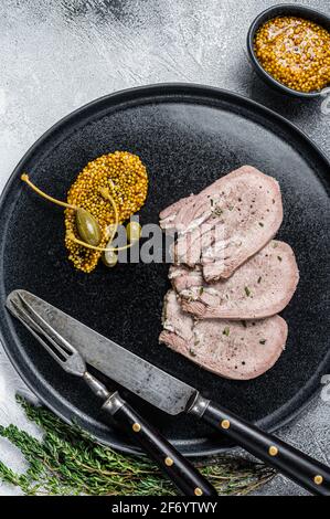 Des tranches de veau ou de bœuf bouillies sur une assiette. Arrière-plan blanc. Vue de dessus Banque D'Images