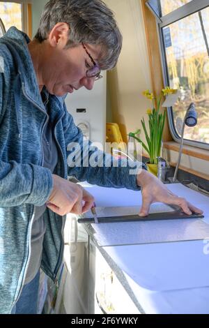 Katherine Webley, artiste du verre, travaille dans son studio de narrowboat, le Pod, pour fabriquer des produits d'art du verre. Banque D'Images