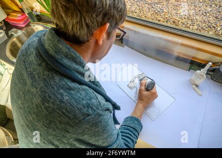 Katherine Webley, artiste du verre, travaille dans son studio de narrowboat, le Pod, pour fabriquer des produits d'art du verre. Banque D'Images