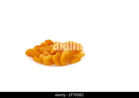 Abricots séchés dans une plaque blanche sur fond blanc Banque D'Images