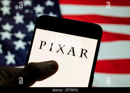 Dans cette illustration de la photo le studio américain de film d'animation d'ordinateur appartenant à Disney, le logo Pixar vu sur un smartphone avec un drapeau des États-Unis en arrière-plan. Banque D'Images