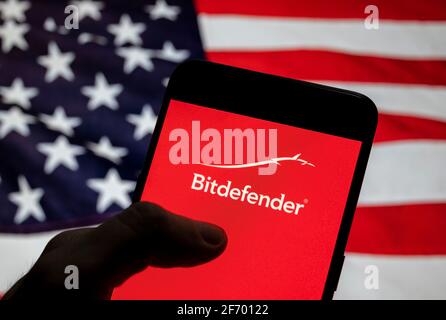 Sur cette photo, le logo de la société roumaine de cybersécurité et d'anti-virus Bitdefender est affiché sur un smartphone avec un drapeau des États-Unis en arrière-plan. Banque D'Images
