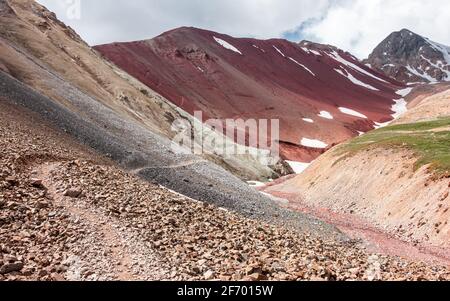 Paysage pittoresque martien rouge avec un sentier près du col de Puteshestvennikov sur le chemin de l'Advanced base Camp de Lénine Peak, Vallée d'Alai, Kirghizistan Banque D'Images