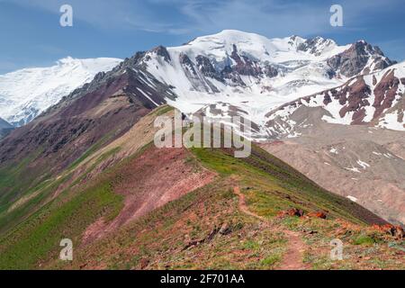 Sentier de montagne sur la crête abrupte par une journée ensoleillée Au pied du pic de Lénine enneigé dans les montagnes de Pamir À la frontière du Kirghizistan et du Tadjikistan Banque D'Images