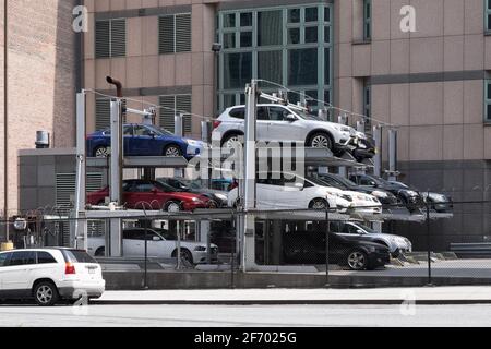 Système de stationnement automatique automatisé à plusieurs étages derrière une clôture le long d'une route à New York, aux États-Unis Banque D'Images