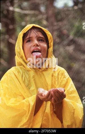 Austin Texas USA, 1997: L'enfant hispanique de quatrième classe aime jouer à l'extérieur pendant une tempête. ©Bob Daemmrich MODÈLE DE SORTIE EV-0061,0062 ©1997 Banque D'Images