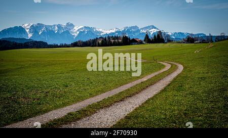 Paysage scène avec champ agricole, arbres, route, neige couvert montagnes et ciel. Suisse. Ambiance tranquille. Banque D'Images