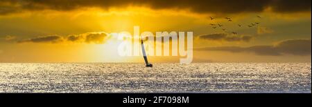 Voilier naviguant vers le soleil de coucher de soleil dans la mer Méditerranée Banque D'Images