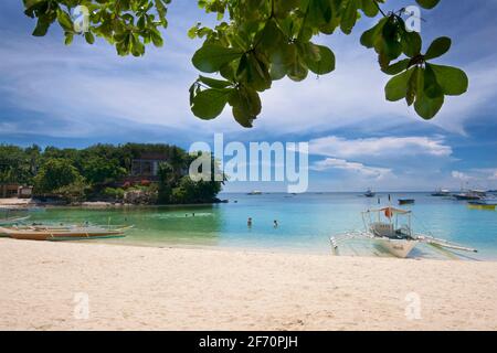 La baie de Logon, île de Malapascua, avec des canoës-outrigger sur la plage de sable blanc. Mer de Visayan, Cebu, Philippines. Banque D'Images