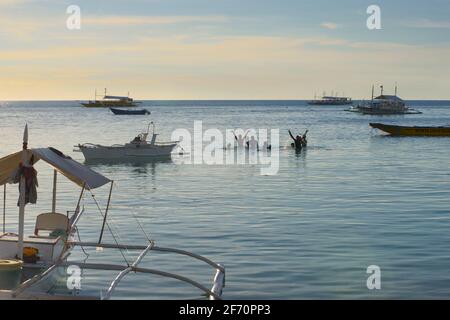 Les habitants de la région profitent de l'eau dans la baie de Logon, île Malapascua. Mer de Visayan, Cebu, Philippines. Banque D'Images