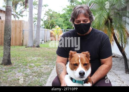 homme avec chien dehors portant un masque Banque D'Images