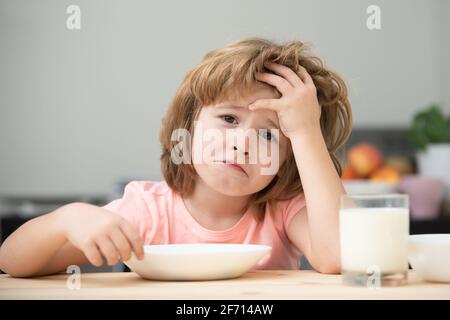 Pas faim. Enfant refusant de manger. L'enfant n'a pas d'appétit. Le petit enfant contrarié refuse de manger des céréales biologiques avec du lait. Nutrition de l'enfant. Banque D'Images