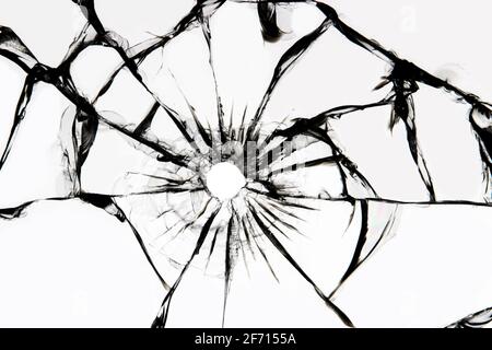 Verre endommagé présentant des fissures, fissures dans le verre résultant de la grenaille. Fenêtre cassée, texture sur fond blanc. Banque D'Images