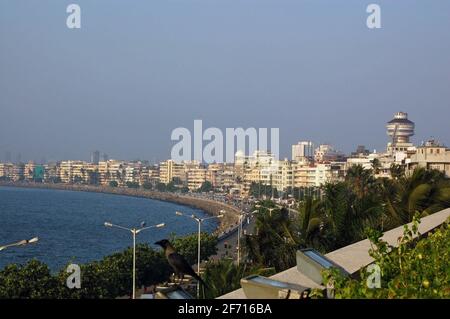 Une vue vers le nord le long de Marine Drive et Back Bay dans la ville de Mumbai (anciennement Bombay) avec l'océan Indien qui s'enclasant contre la plage. Banque D'Images