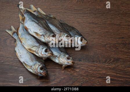 quelques poissons séchés sur un fond en bois foncé/ Banque D'Images