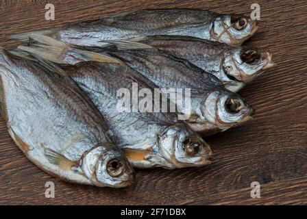 quelques poissons séchés sur un fond en bois foncé/ Banque D'Images