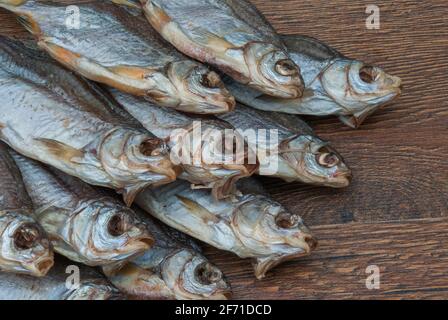 quelques poissons séchés sur un fond en bois foncé/ Banque D'Images